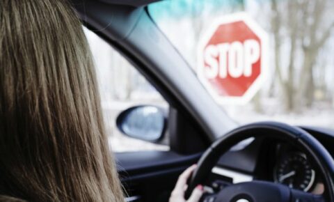 Fahrschülerin schaut auf Stopschild.