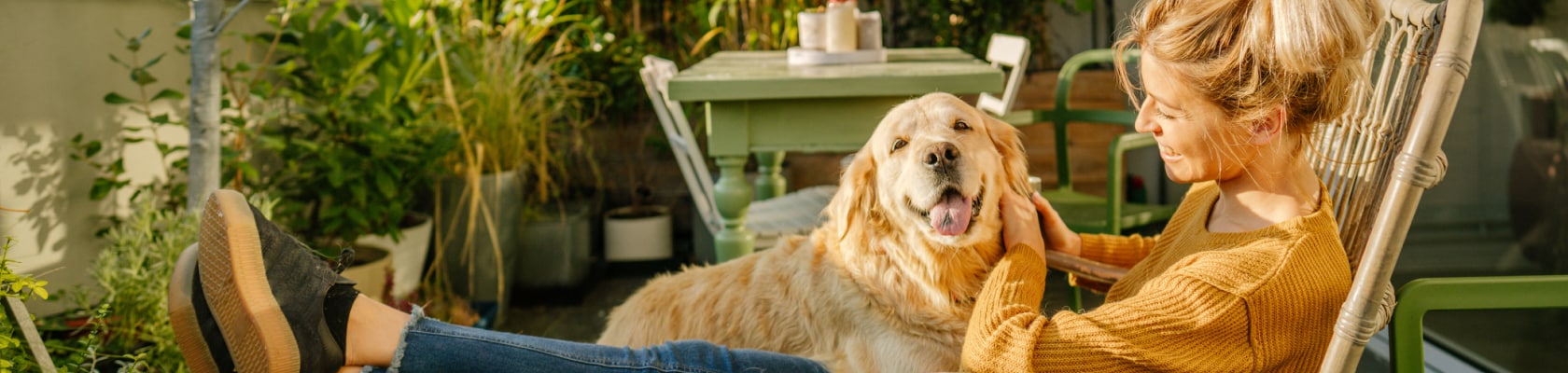 Frau mit Hund auf dem Balkon.