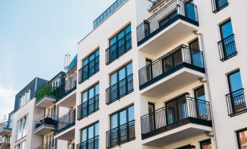 Fassade eines Hauses mit mehreren Wohnungen und Balkonen.