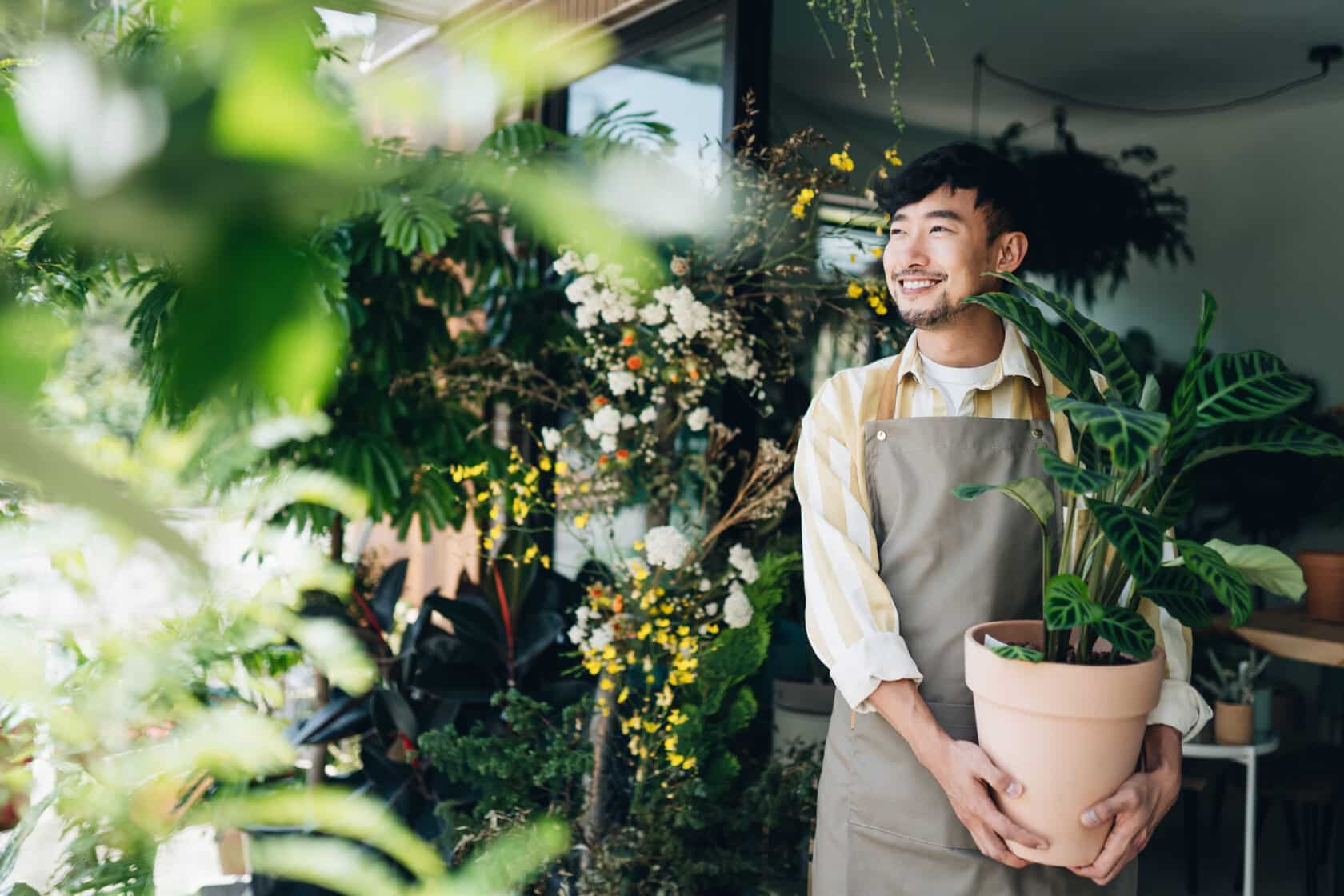 Fröhlicher Mann im Blumenladen